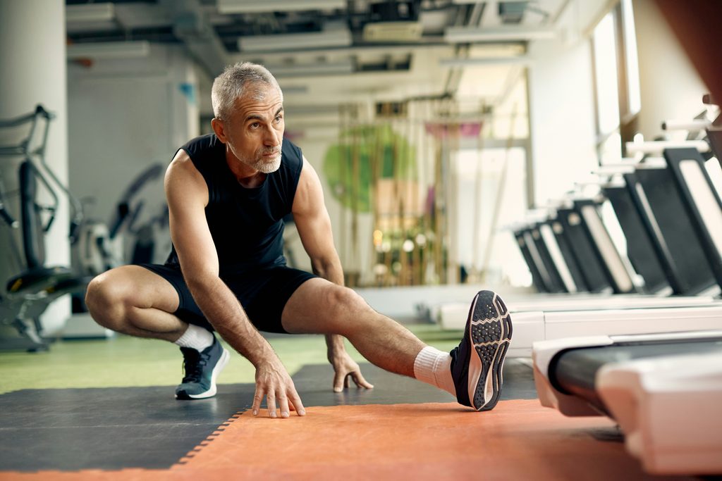 Man stretching at the gym during testosterone therapy